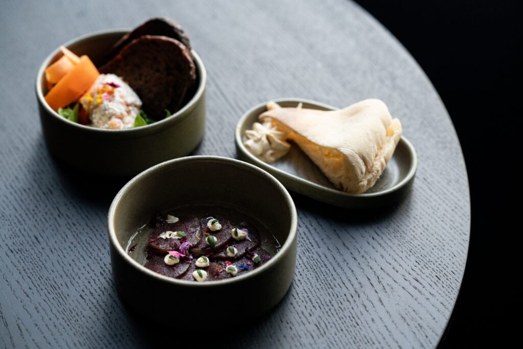 Small dishes of local Lapland food served on a dark round table.